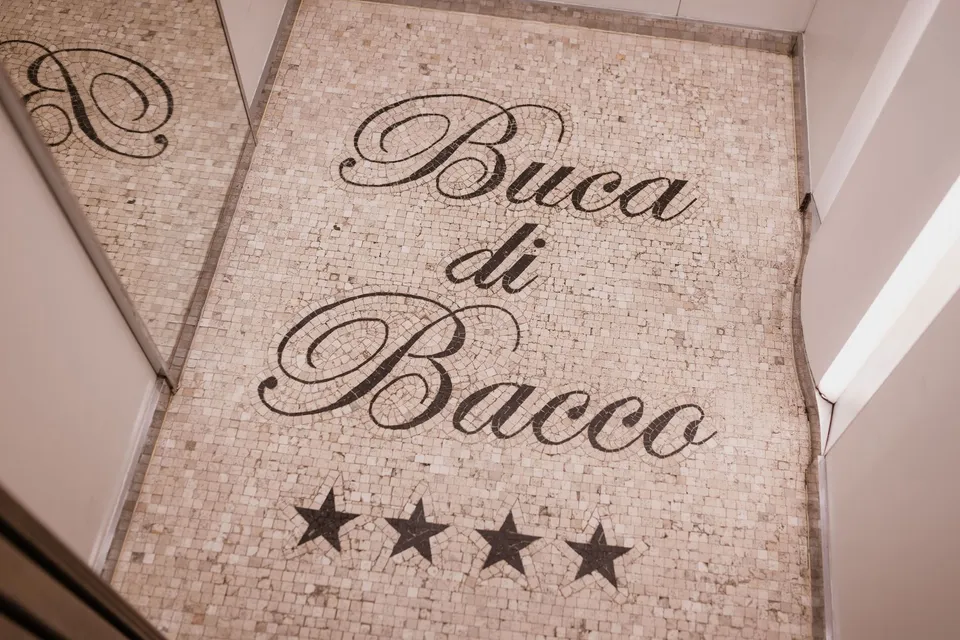 The Buca di Bacco name written in a mosaic at the hotel entrance, at Hotel Buca di Bacco in Positano, Amalfi Coast, Italy, for an Elopement Collective elopement. Photograph by Jason Corroto.