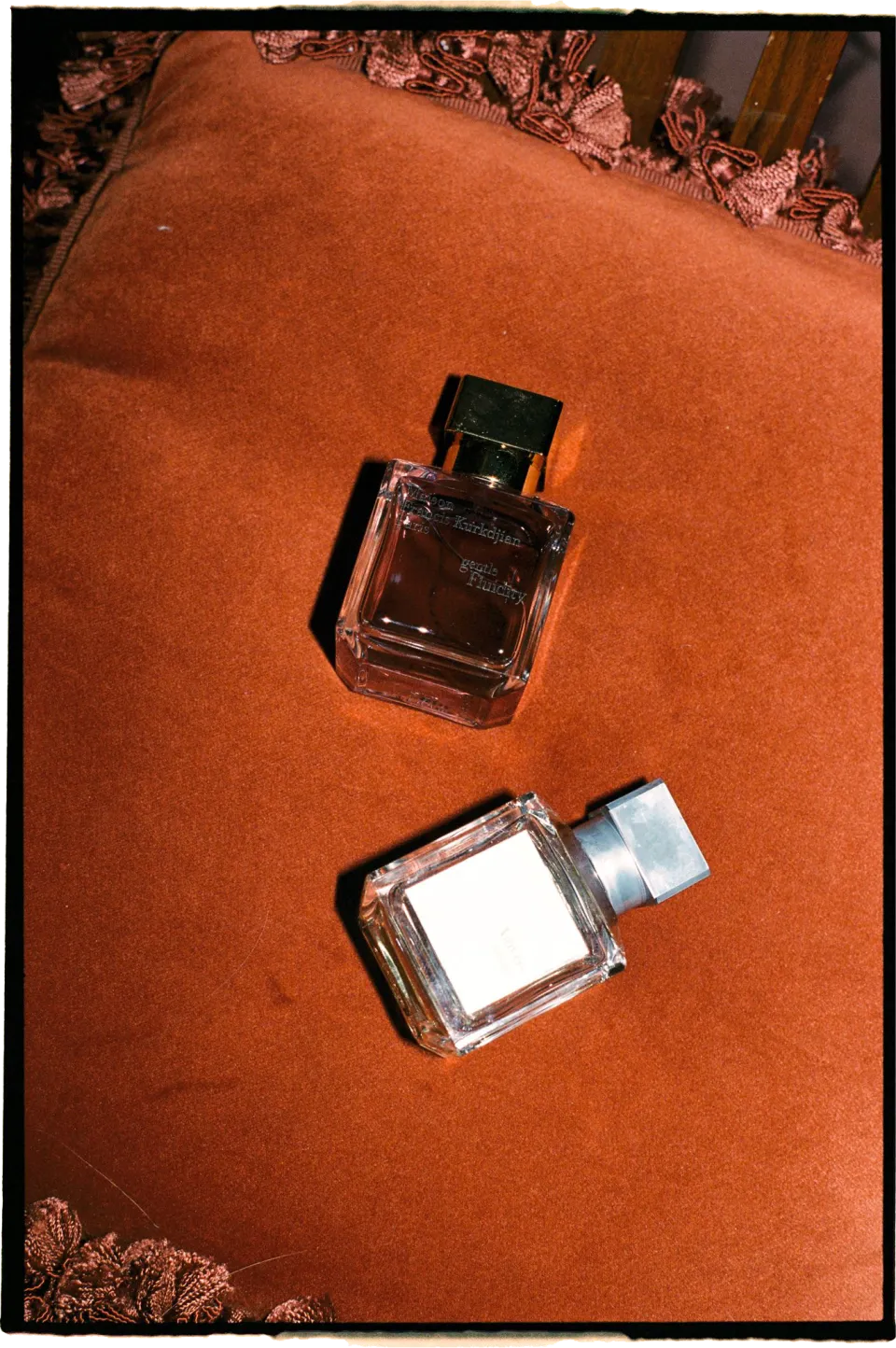 Two perfume bottles arranged on an orange upholstered chair, at Villa San Michele in Fiesole above Florence, Tuscany, Italy, for an Elopement Collective elopement. Film photograph by Khara from House of Lucie.