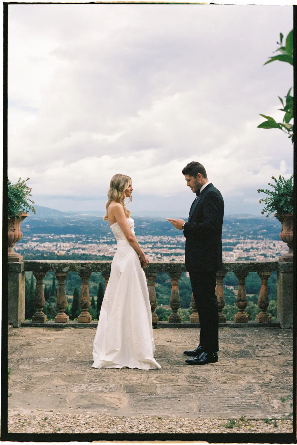 Matthew reading his vows to Holly on the terrace overlooking Florence, at Villa San Michele in Fiesole above Florence, Tuscany, Italy, for an Elopement Collective elopement. Film photograph by Khara from House of Lucie.