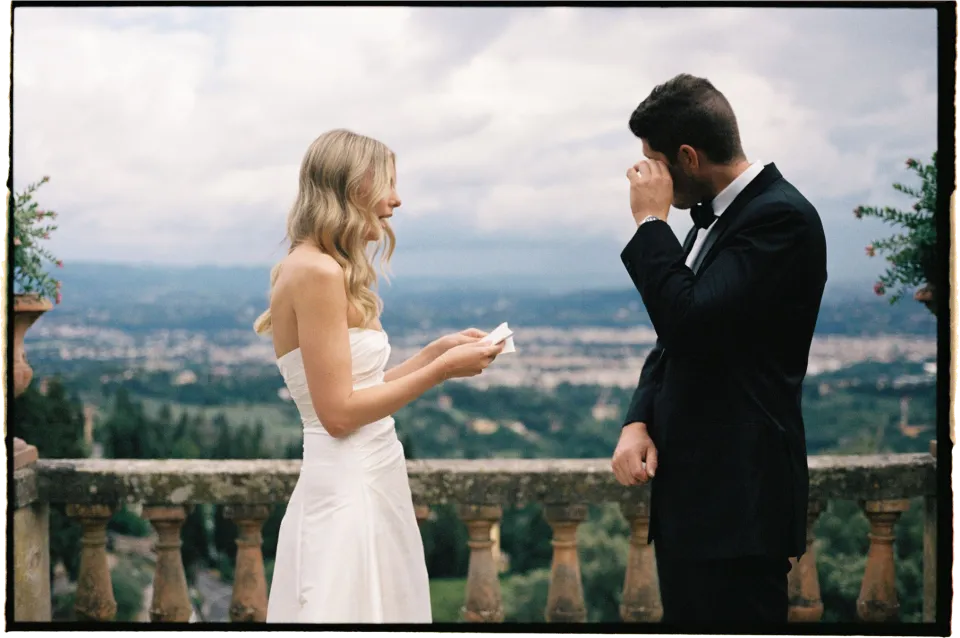 Matthew wiping his eye while Holly reads from her vow card, at Villa San Michele in Fiesole above Florence, Tuscany, Italy, for an Elopement Collective elopement. Film photograph by Khara from House of Lucie.