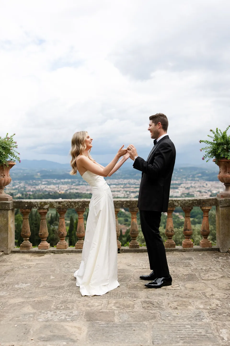 Holly and Matthew facing each other with their hands raised together during the ceremony, at Villa San Michele in Fiesole above Florence, Tuscany, Italy, for an Elopement Collective elopement. Digital photograph by Khara from House of Lucie.