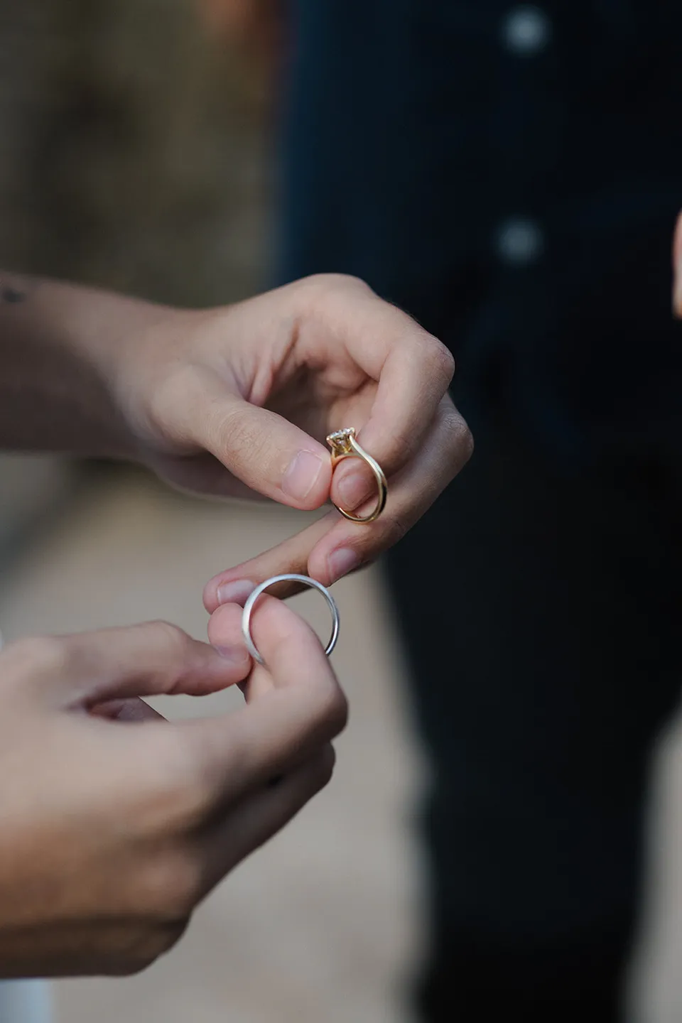 Close-up of the couple's hands holding their wedding rings. At Whites Beach, Broken Head, near Byron Bay, for an Elopement Collective elopement. Photograph by Jason Lucas.