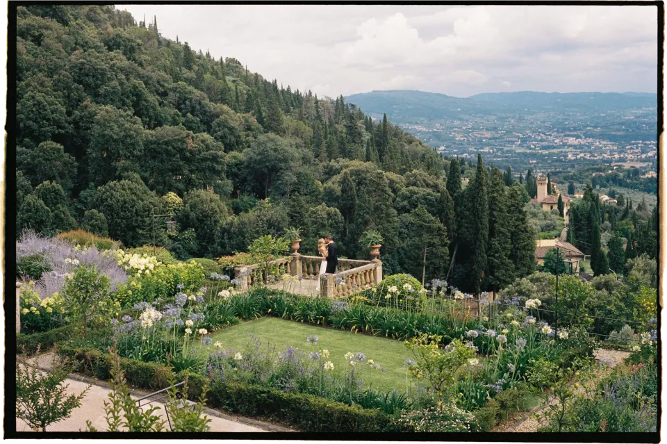 The villa’s flower-filled terraced garden, wooded hills and Florence skyline, at Villa San Michele in Fiesole above Florence, Tuscany, Italy, for an Elopement Collective elopement. Film photograph by Khara from House of Lucie.