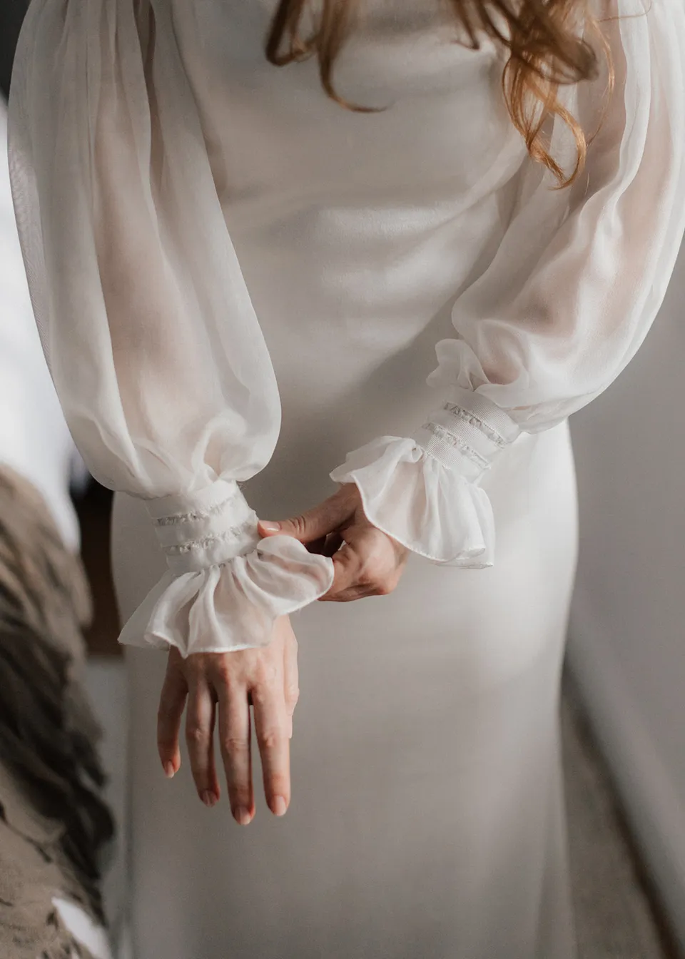 Close-up of Elyse's hands and the gathered cuffs of her sheer sleeves. At Fig Tree Villa in Ewingsdale, Byron Bay, for an Elopement Collective elopement. Photograph by Bulb Creative.