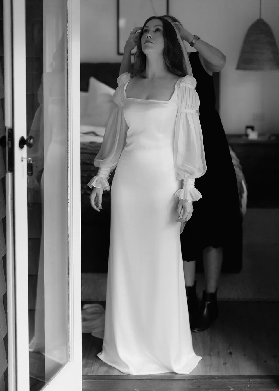 Black-and-white photograph of Elyse having her veil fitted. At Fig Tree Villa in Ewingsdale, Byron Bay, for an Elopement Collective elopement. Photograph by Bulb Creative.