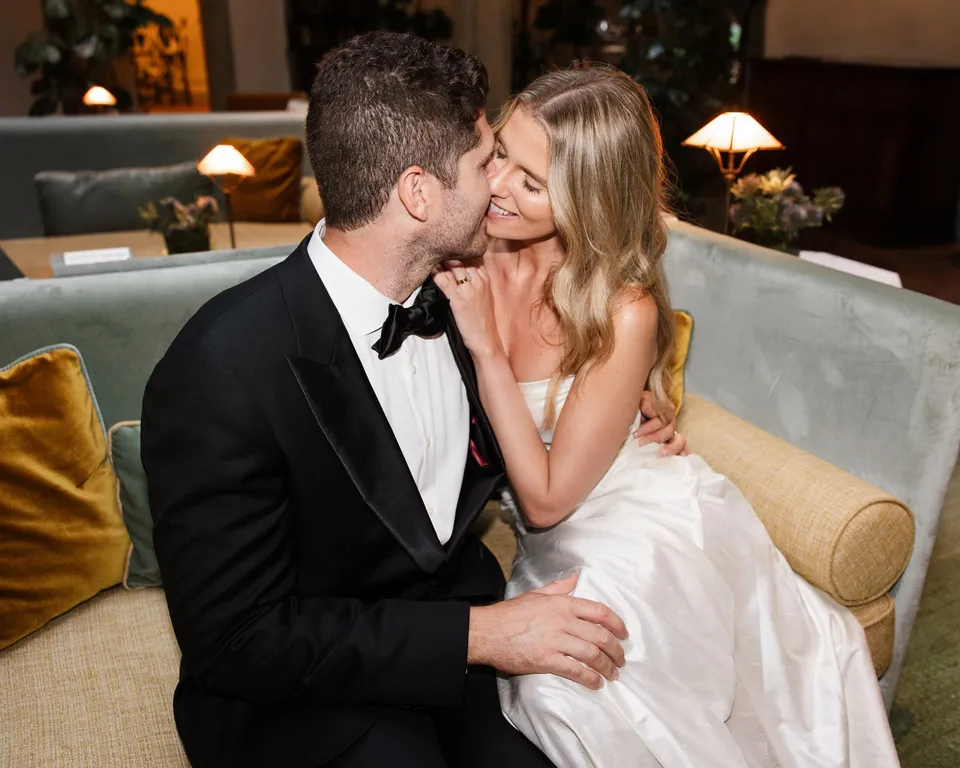 Matthew kissing Holly’s cheek as they sit together on a sofa inside the villa, at Villa San Michele in Fiesole above Florence, Tuscany, Italy, for an Elopement Collective elopement. Digital photograph by Khara from House of Lucie.