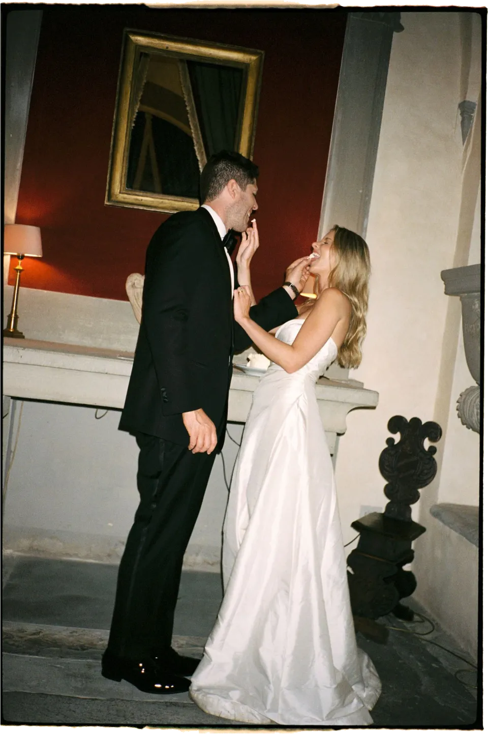 Holly and Matthew laughing together inside the villa, Holly’s hand touching his face, at Villa San Michele in Fiesole above Florence, Tuscany, Italy, for an Elopement Collective elopement. Film photograph by Khara from House of Lucie.