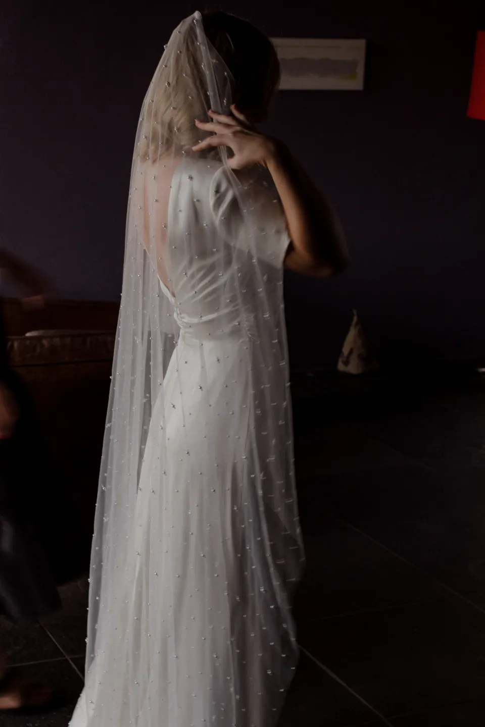 Jemmah adjusting her long veil before the ceremony, at Thalia Haven on the East Coast of Tasmania, Australia, for an Elopement Collective elopement. Photograph by Joey Willis.