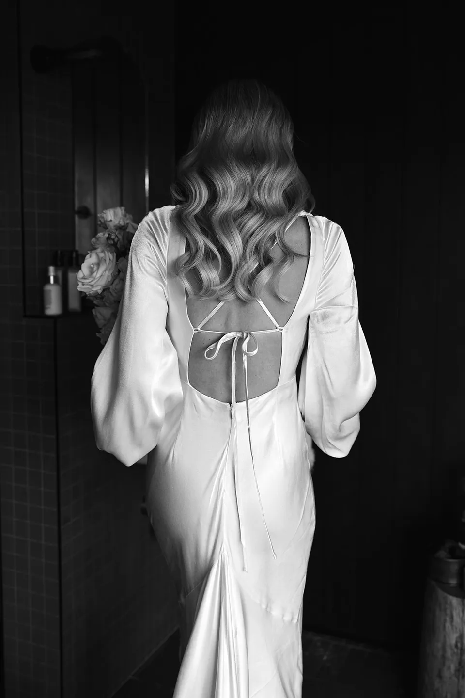 Black-and-white portrait of Gabrielle’s loose waves styled by Sian Howard Bridal and her open-back Shona Joy dress inside the cabin, at Roundhill Retreat in Obi Obi, Sunshine Coast Hinterland, Queensland, for an Elopement Collective elopement. Photo by George Bowden.