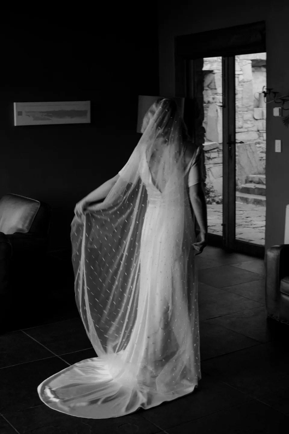 Black and white portrait of Jemmah turning in her dress and veil, at Thalia Haven on the East Coast of Tasmania, Australia, for an Elopement Collective elopement. Photograph by Joey Willis.