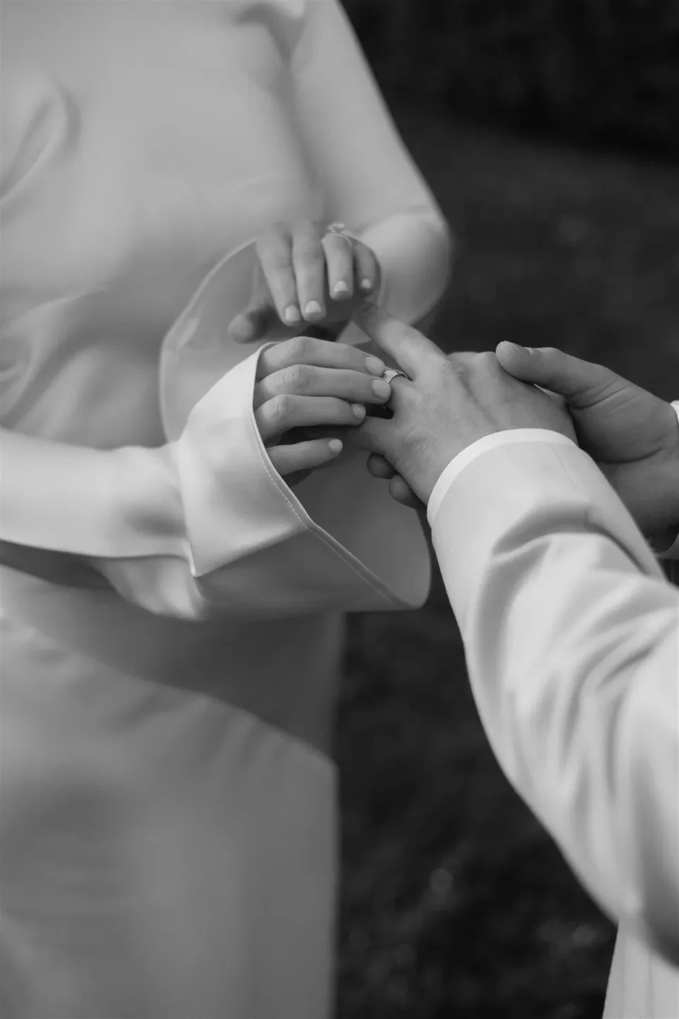 Black-and-white close-up of Cameron placing a wedding ring on Maddy’s hand, at The Mayor’s Residence in Daylesford, Victoria, for an Elopement Collective elopement. Photo by Bulb Creative.