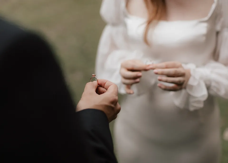 Close-up of Elyse preparing to place Jonathan's wedding ring. At Fig Tree Villa in Ewingsdale, Byron Bay, for an Elopement Collective elopement. Photograph by Bulb Creative.