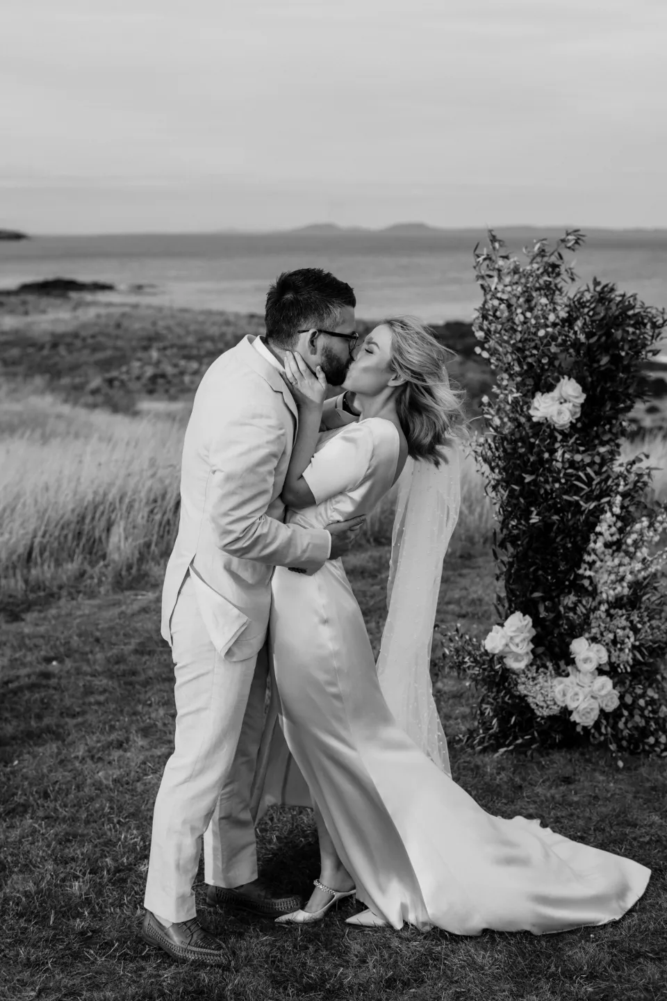 Black and white photograph of Jemmah and Jack kissing after their vows, at Thalia Haven on the East Coast of Tasmania, Australia, for an Elopement Collective elopement. Photograph by Joey Willis.