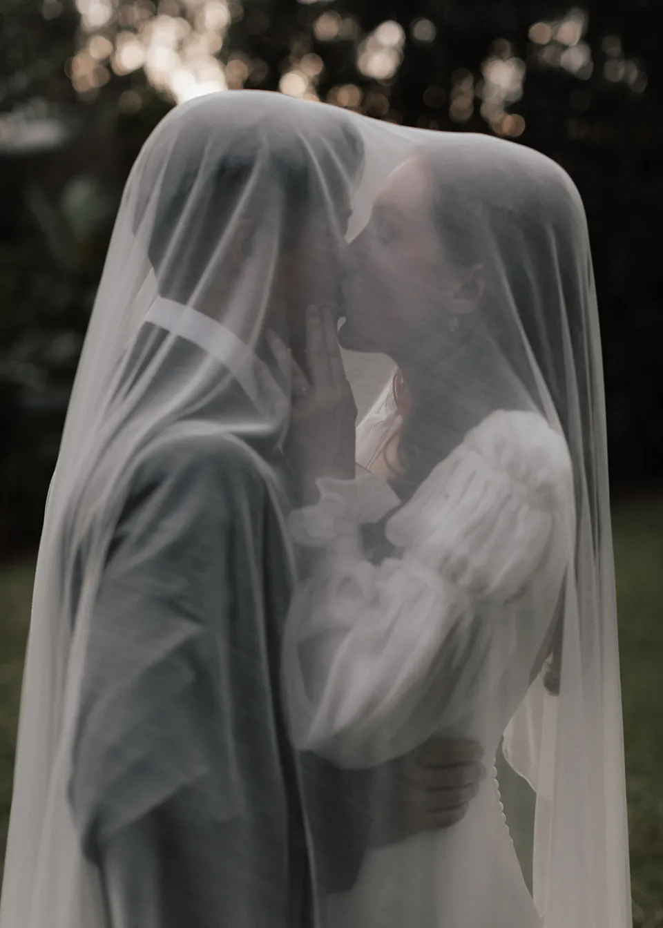 Elyse and Jonathan kissing beneath her sheer veil. At Fig Tree Villa in Ewingsdale, Byron Bay, for an Elopement Collective elopement. Photograph by Bulb Creative.