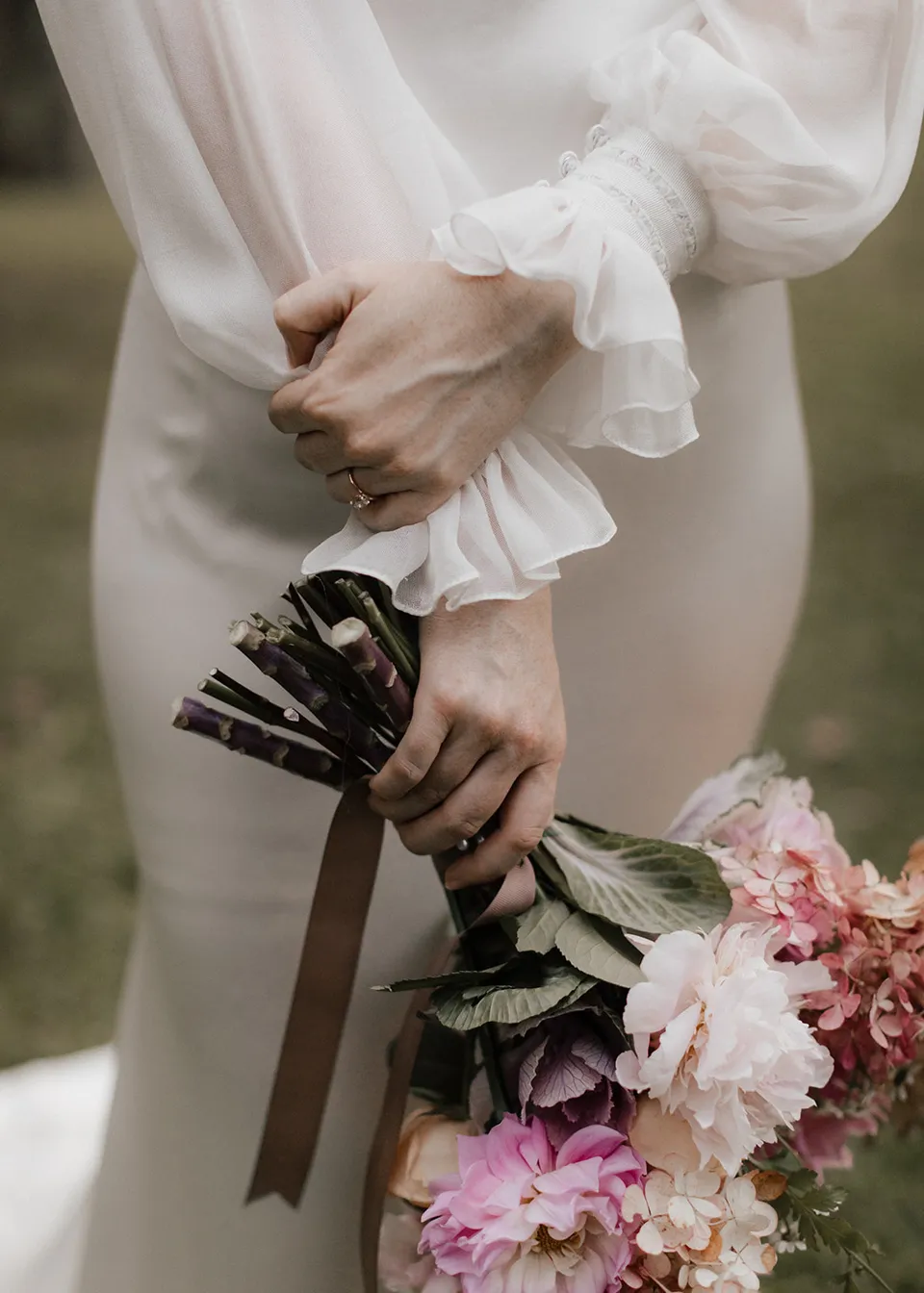 Close-up of Elyse's wedding ring, sheer cuffs and bouquet, with flowers by The Perfect Party Co. At Fig Tree Villa in Ewingsdale, Byron Bay, for an Elopement Collective elopement. Photograph by Bulb Creative.