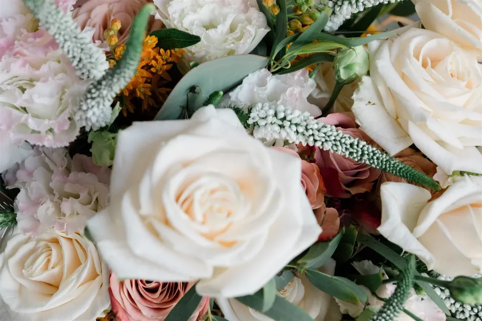 Close-up of blush and white roses, pale pink flowers and green foliage arranged by Floral Garden Positano, at Alcione Residence in Positano, Amalfi Coast, Italy, for an Elopement Collective elopement. Photo by James from House of Love.