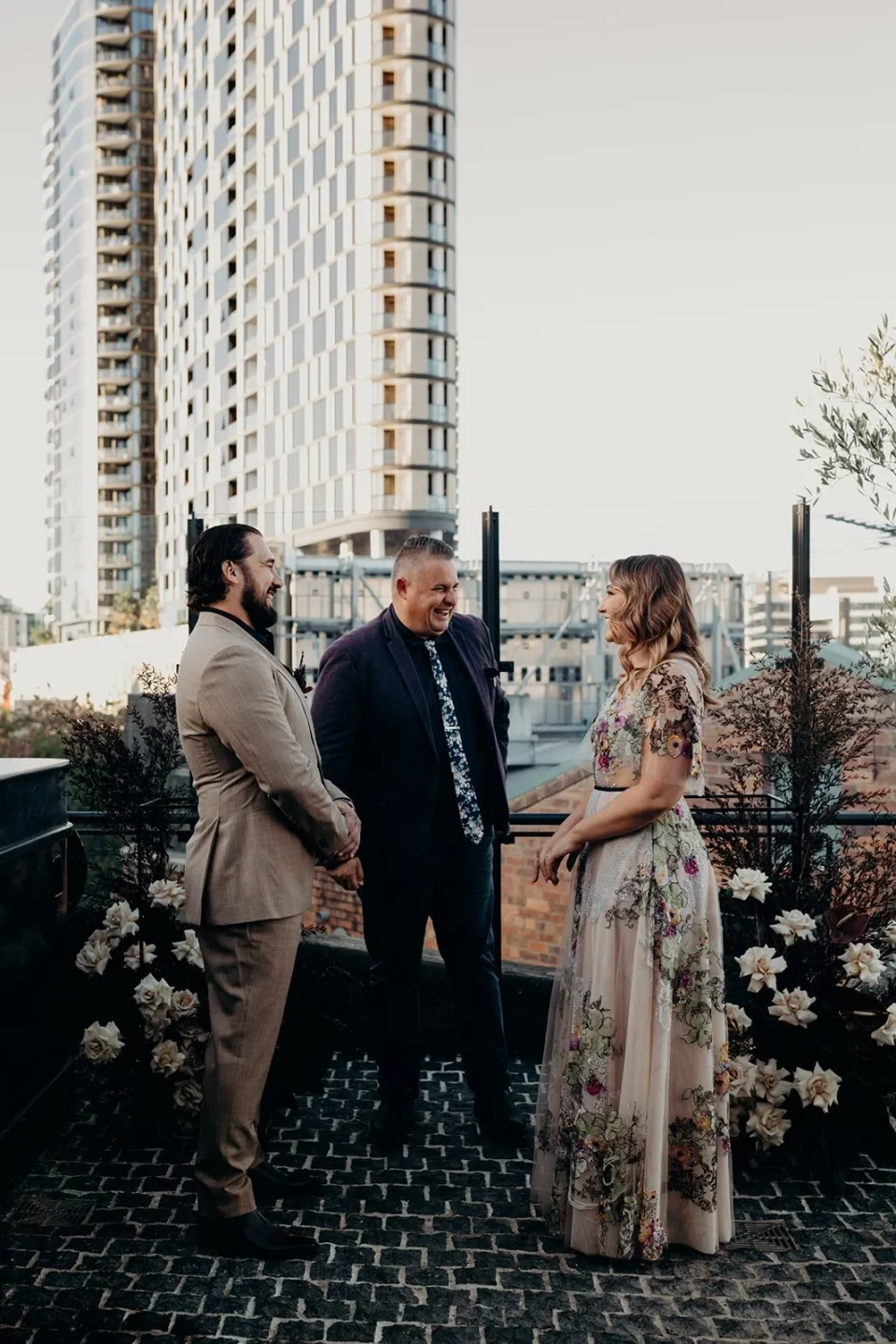 Victoria speaking during the ceremony with Daniel and celebrant Josh Withers listening, at Agnes Restaurant in Fortitude Valley, Brisbane, for an Elopement Collective elopement. Photo by Tessa Shannon.
