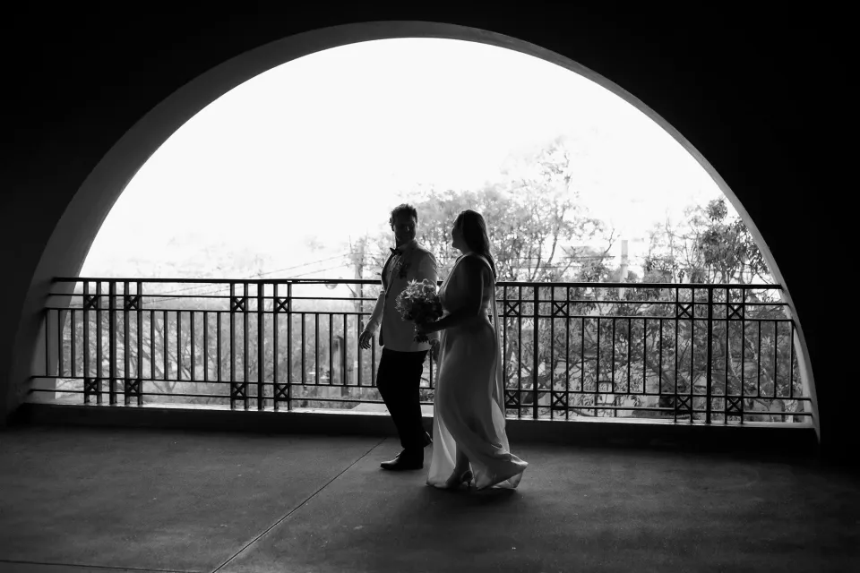 Black-and-white portrait of Alyce and Andrew silhouetted together beneath a stone arch, in The Rocks, Sydney, New South Wales, for an Elopement Collective elopement. Photo by Jason Corroto.