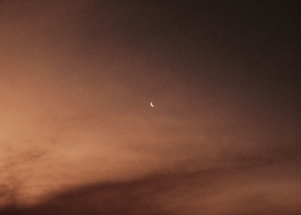 On 35mm film: A small moon above warm clouds in the evening sky. At Fig Tree Villa in Ewingsdale, Byron Bay, for an Elopement Collective elopement. Photograph by Bulb Creative.
