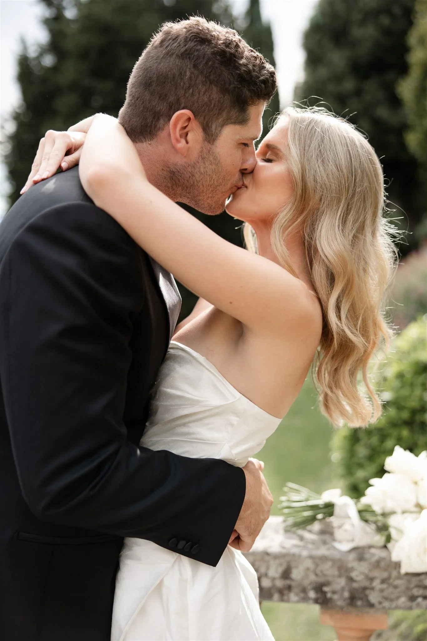 Close portrait of Holly and Matt kissing, her arms wrapped around his shoulders, at Belmond Villa San Michele in Fiesole, overlooking Florence, Tuscany, Italy, for an Elopement Collective elopement. Photo by Khara from House of Lucie.