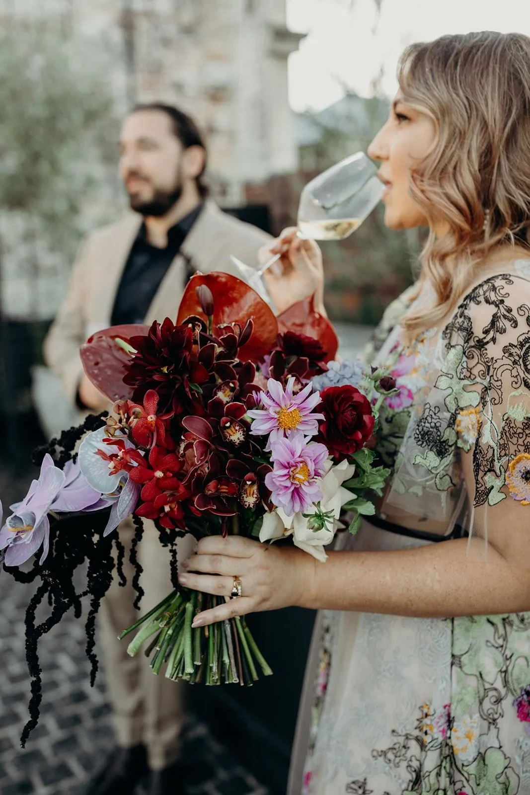Victoria drinking sparkling wine beside Daniel while holding her bouquet by Mrs Gibbons Flowers, at Agnes Restaurant in Fortitude Valley, Brisbane, for an Elopement Collective elopement. Photo by Tessa Shannon.