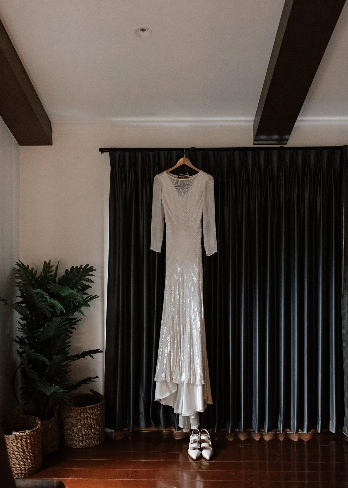 April’s long-sleeved Karen Willis Holmes dress hanging above her white shoes, at Cradle Mountain Lodge in Cradle Mountain, Tasmania, for an Elopement Collective elopement. Photo by Bulb Creative.