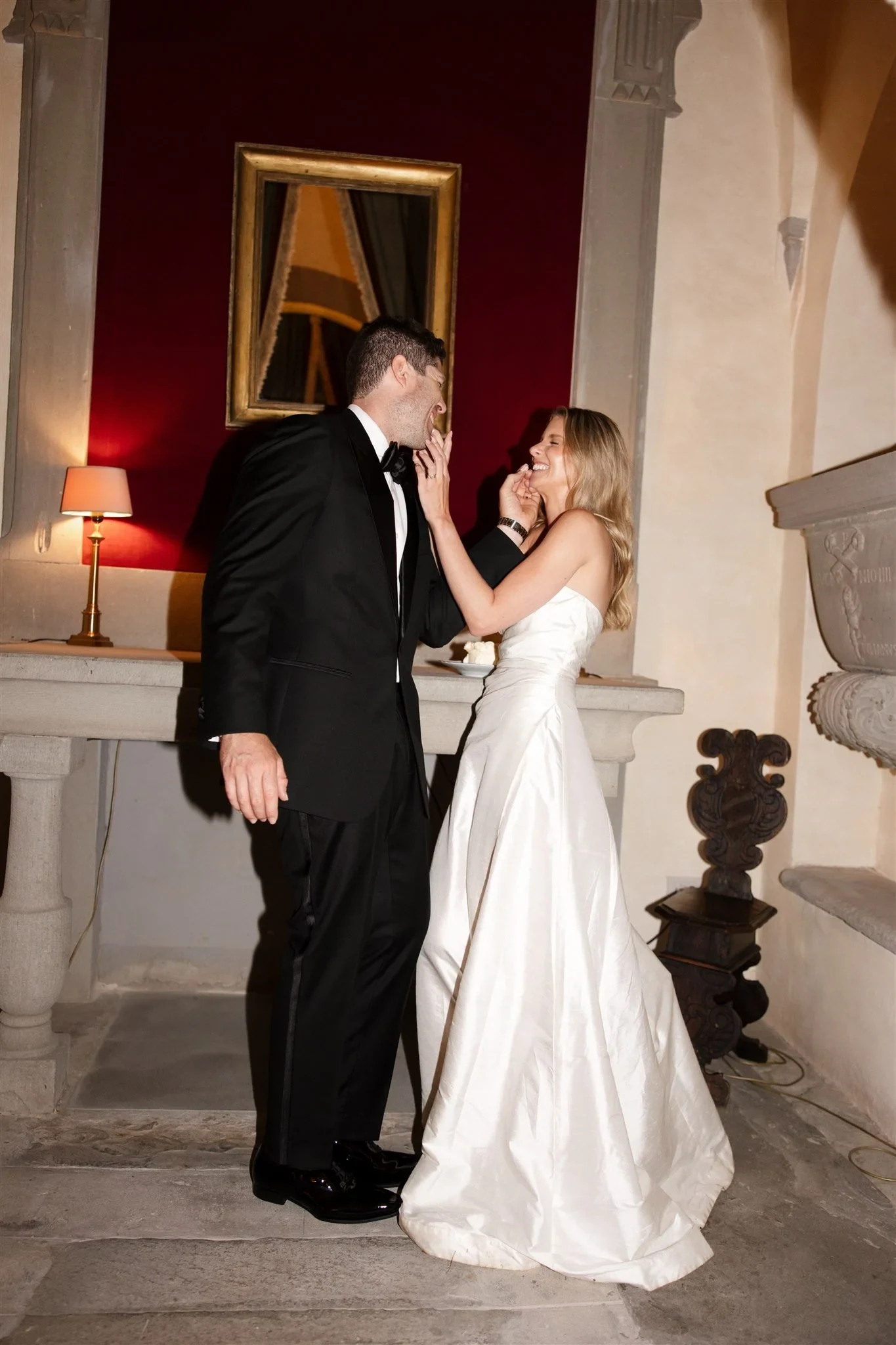 Holly feeding Matt cake inside the villa’s stone-walled room, at Belmond Villa San Michele in Fiesole, overlooking Florence, Tuscany, Italy, for an Elopement Collective elopement. Photo by Khara from House of Lucie.