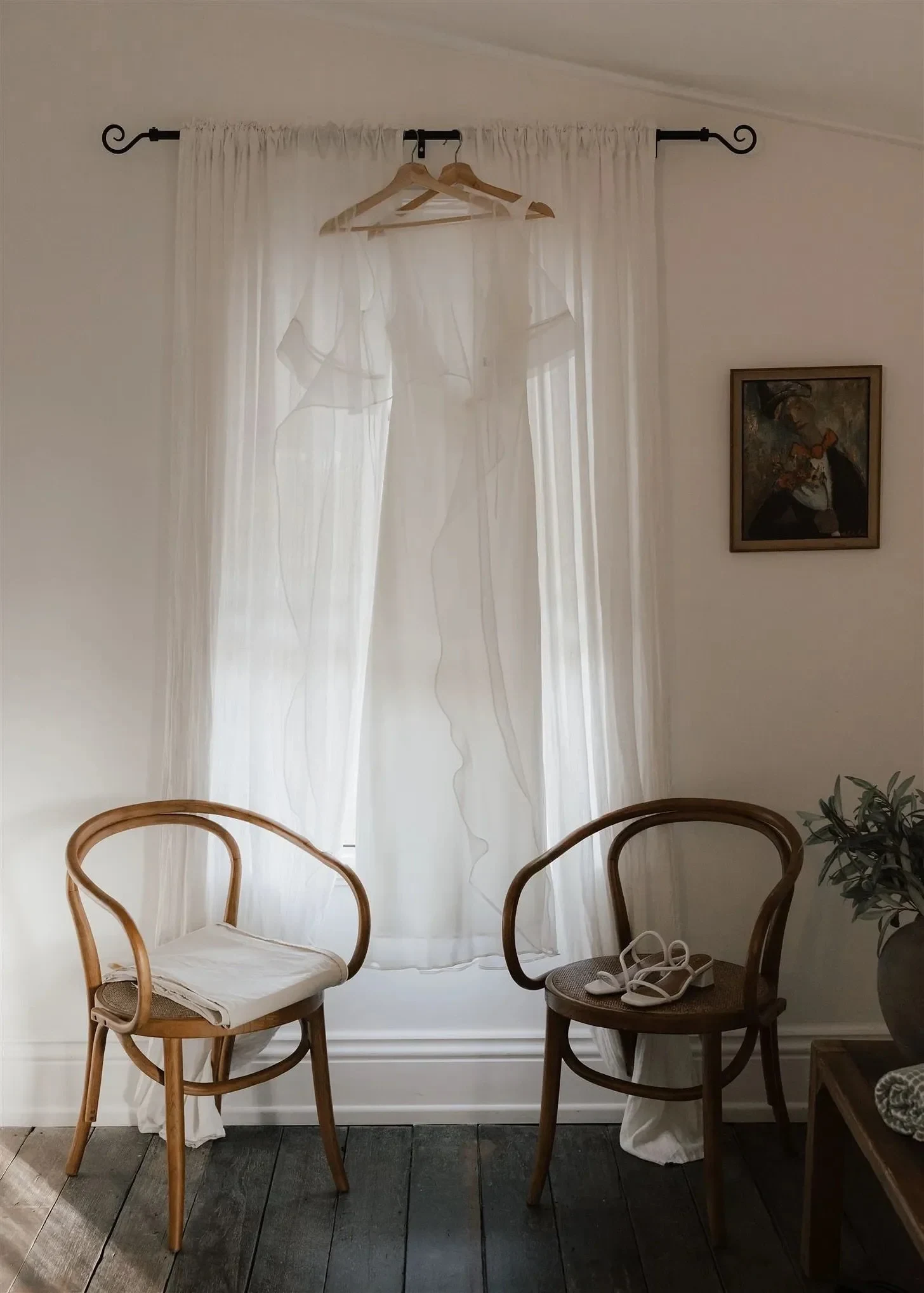 Tineeka’s white dress and blouse by Lilia Cass Ceremonial hanging above two timber chairs, in Montville, Sunshine Coast Hinterland, Queensland, for an Elopement Collective elopement. Photo by Bulb Creative.