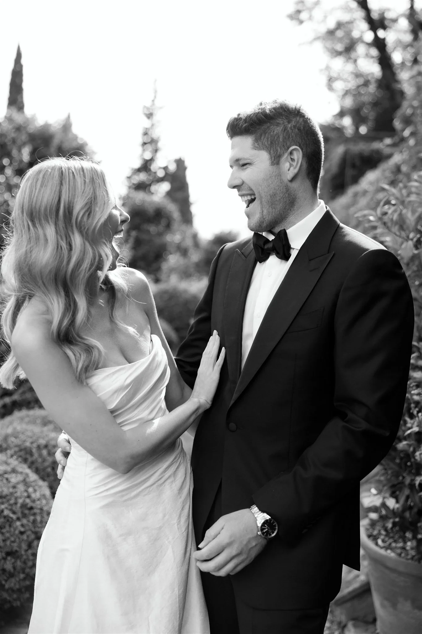 Black-and-white close-up of Holly smiling at Matt with her hand resting on his jacket, at Belmond Villa San Michele in Fiesole, overlooking Florence, Tuscany, Italy, for an Elopement Collective elopement. Photo by Khara from House of Lucie.