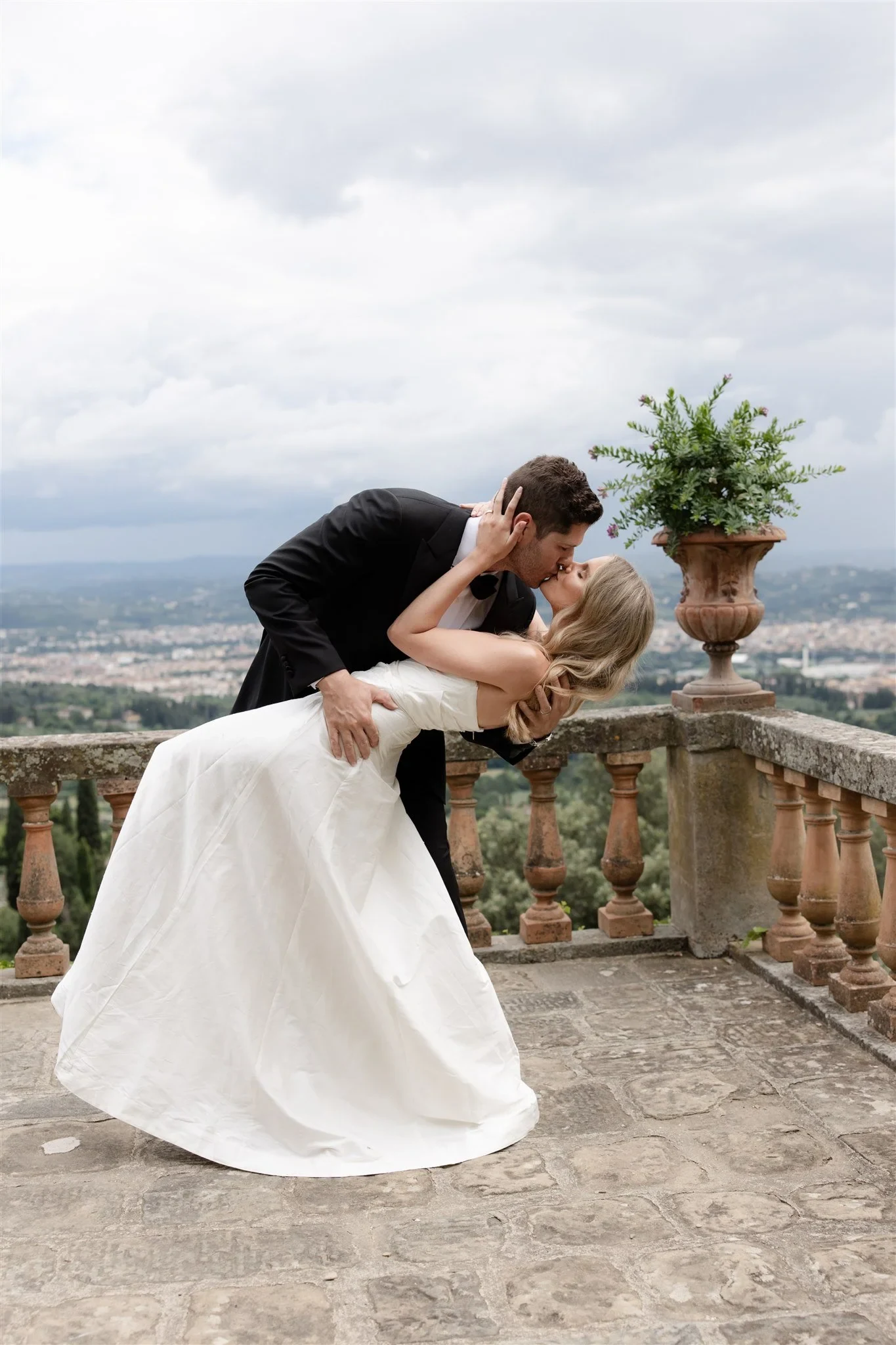 Matt dipping Holly into a kiss on the terrace above Florence, at Belmond Villa San Michele in Fiesole, overlooking Florence, Tuscany, Italy, for an Elopement Collective elopement. Photo by Khara from House of Lucie.